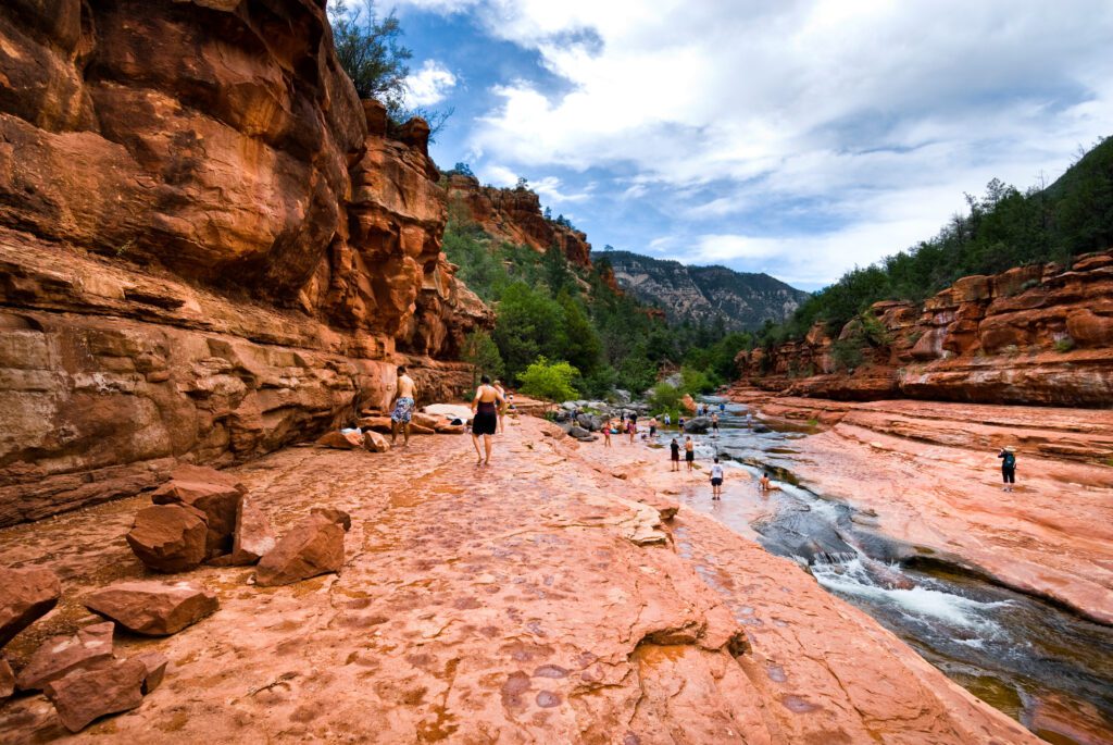 People enjoying the natural water slide at Rock Creek State Park in Sedona, Arizona.